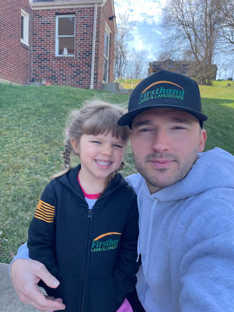 Ryan H., founder of Firsthand Lawn and Landscape, with his daughter in Firsthand-branded gear